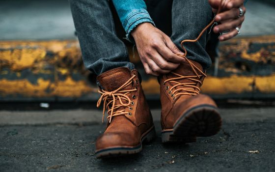 Putting on boots (Unsplash/Nathan Dumlao)